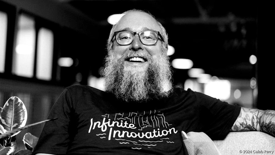 A man is holding a cat in his arms in a black and white photo