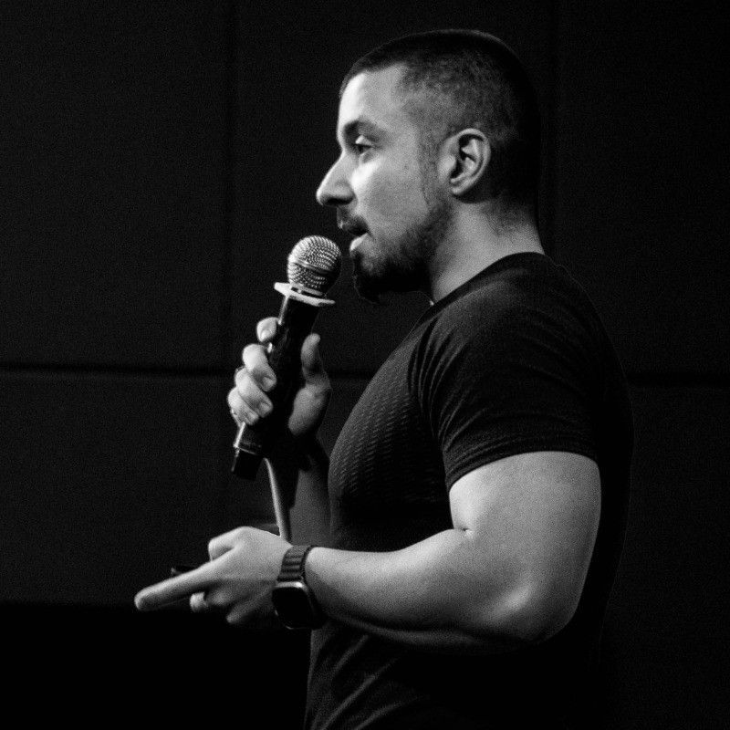 A man is holding a cat in his arms in a black and white photo