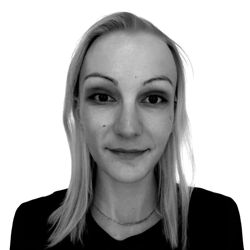 A woman with long hair and hoop earrings is smiling in a black and white photo.