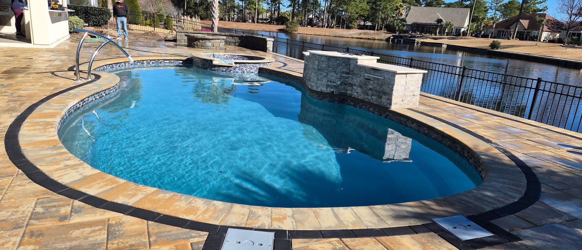 Swimming pool with blue water and stone surround.