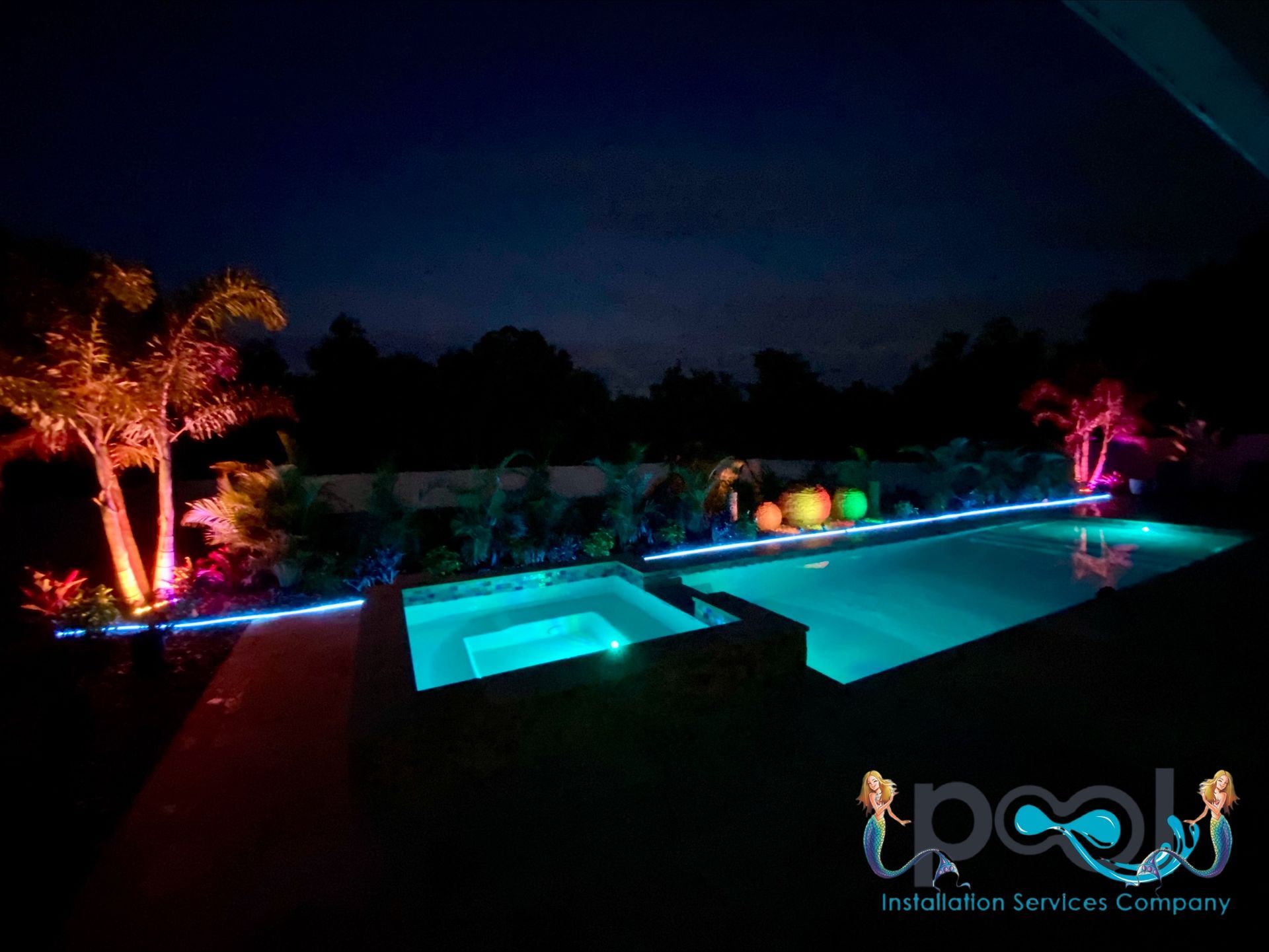 Woman in straw hat smiles, holding wine glass near a lake.