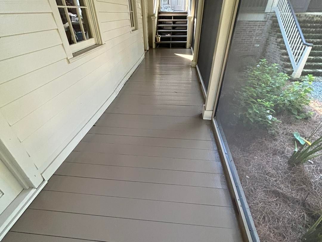 A gray-painted wooden porch with a screened-in side. White house on the left.