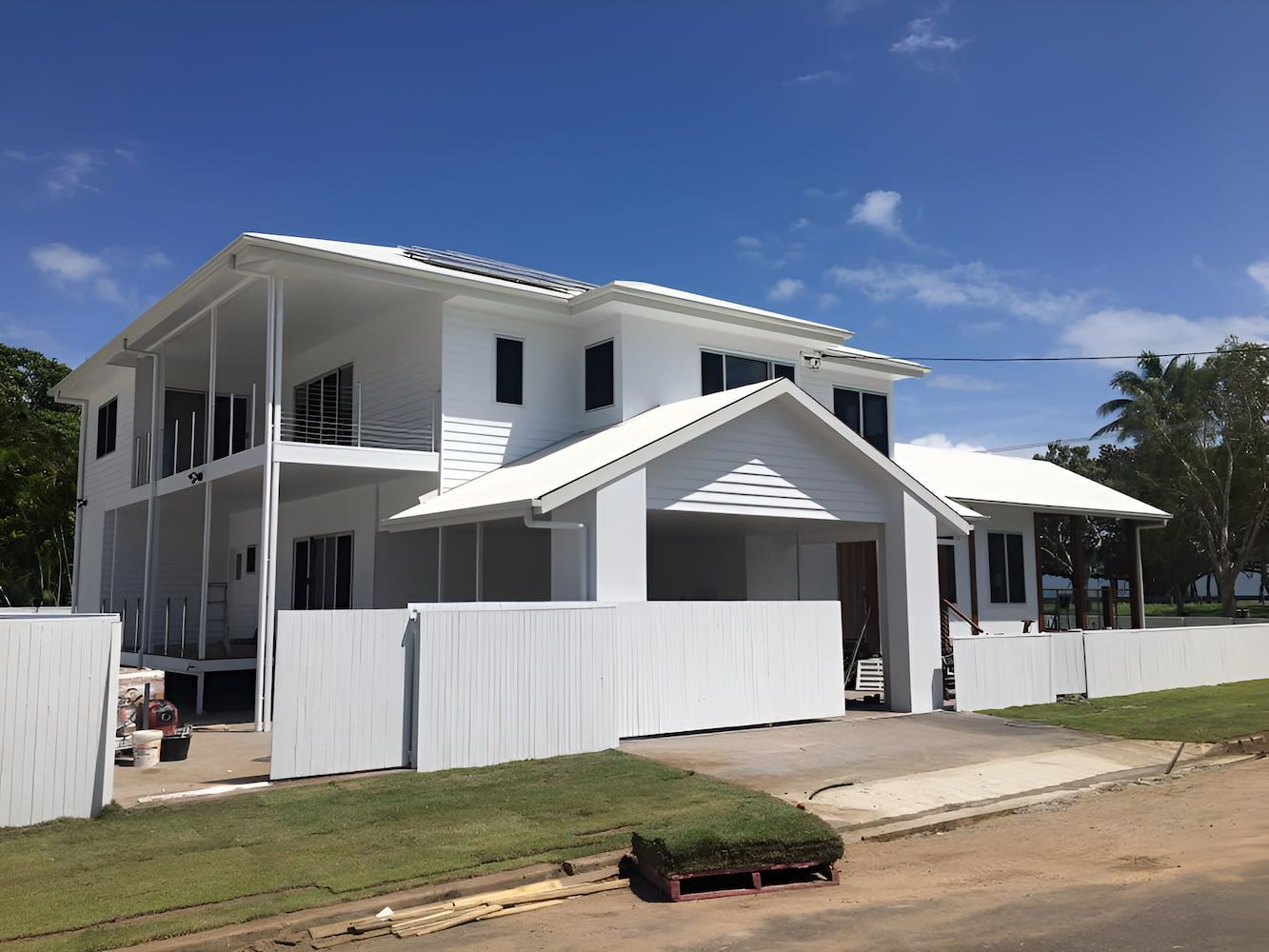 A Newly Painted  Large White House With A White Fence In Front Of It — Marteene Painting Services In Kirwan, QLD
