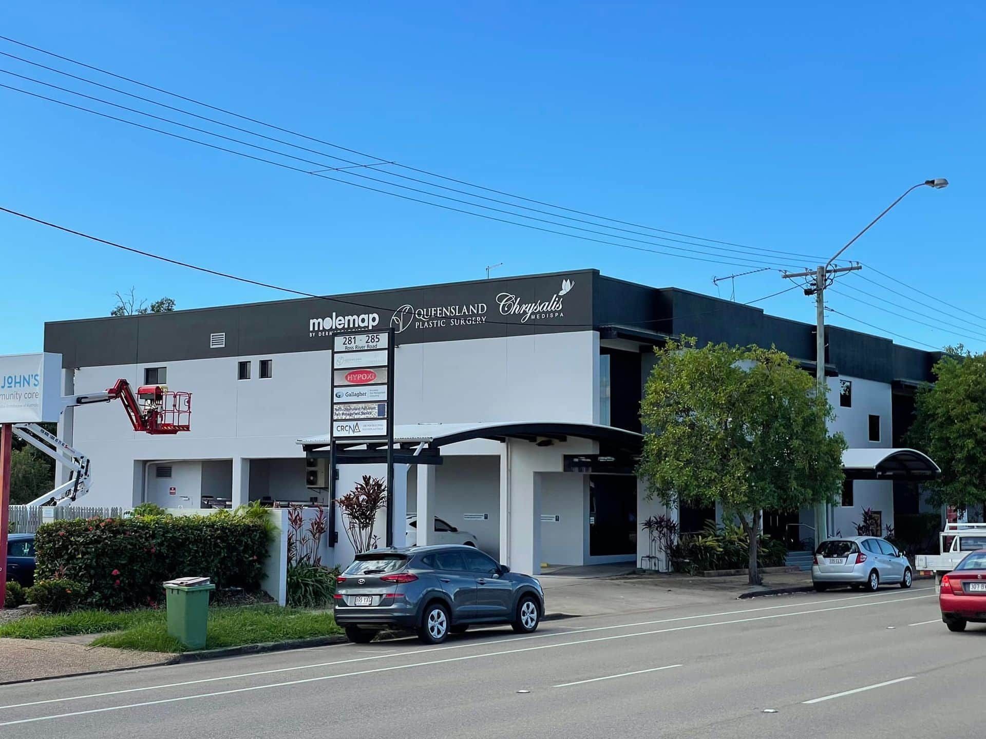 A car is parked in front of a large white building