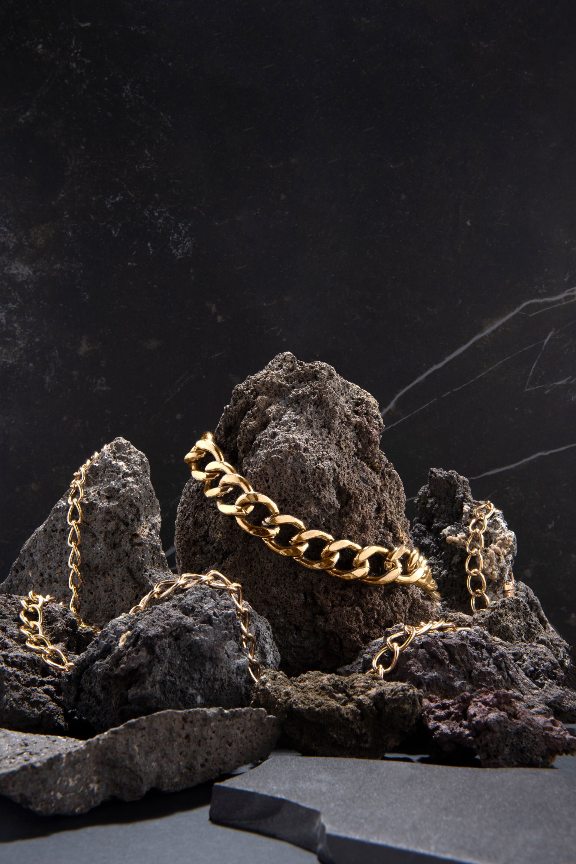 A gold chain is sitting on top of a pile of rocks