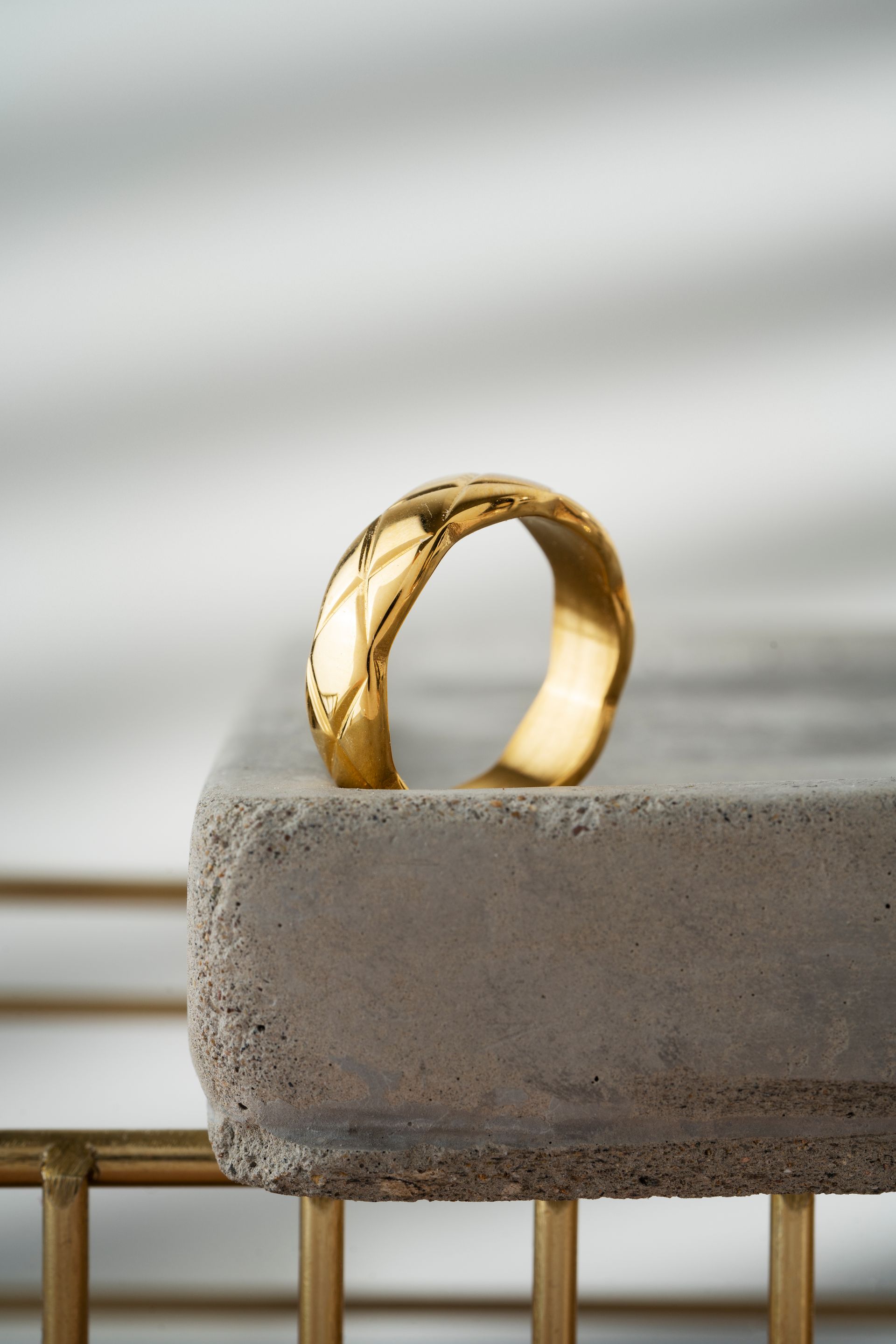 A gold ring is sitting on top of a concrete block.