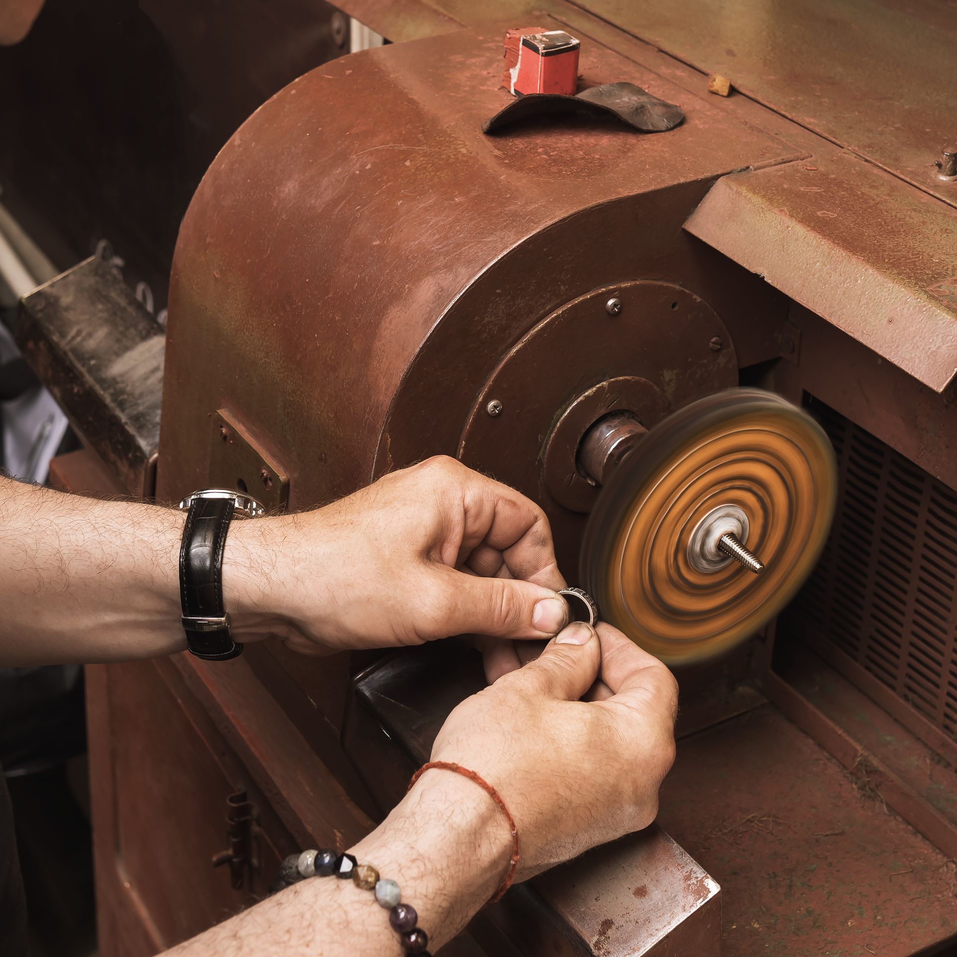 A person is polishing a ring on a machine