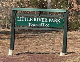 Sign for Little River Park in the Town of Lee, green lettering on a wooden sign.
