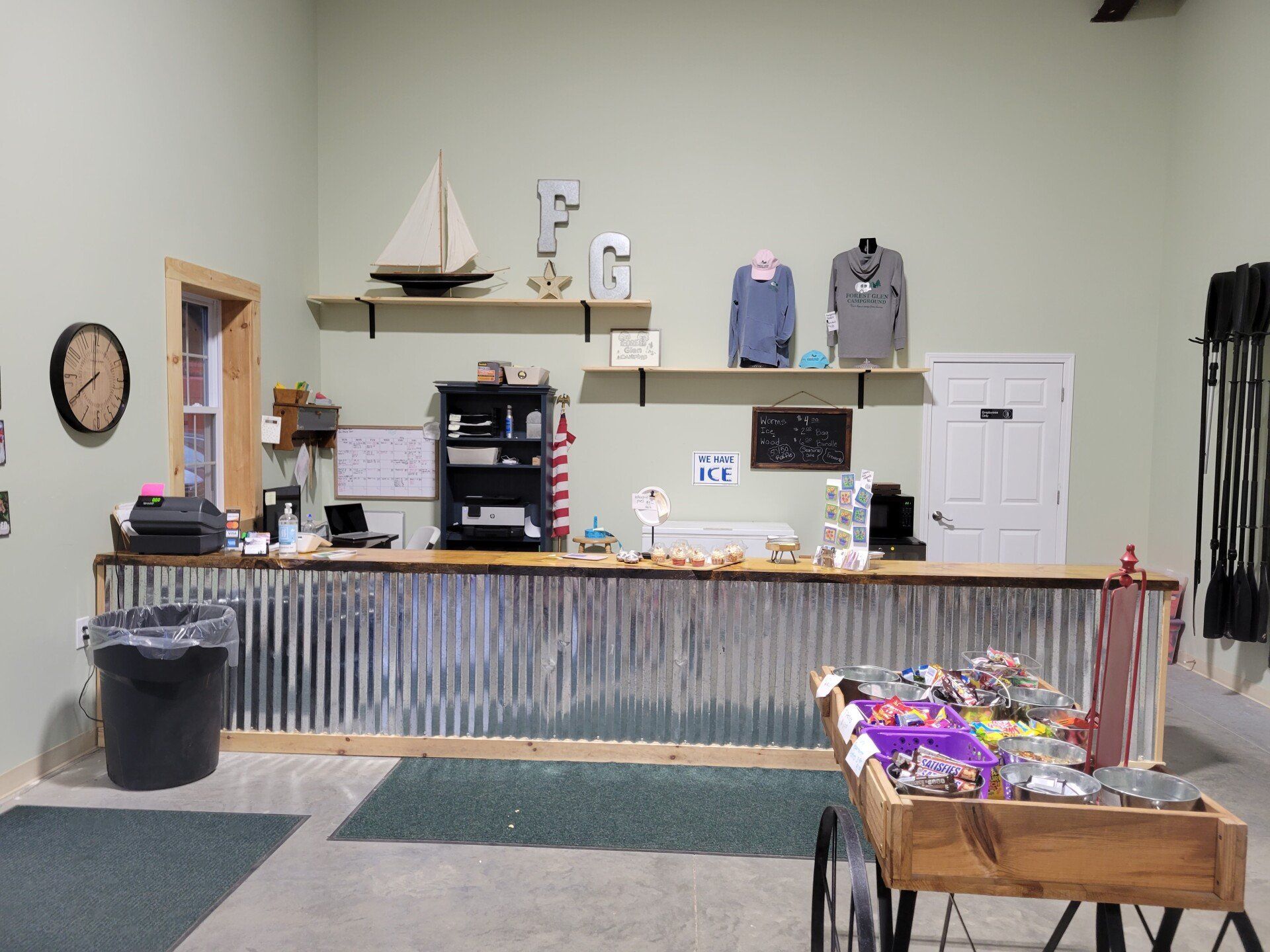 A small shop interior with a counter, merchandise, and wall decor.