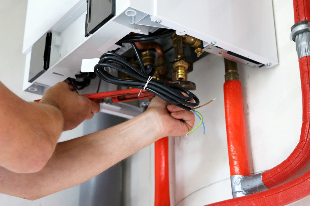 Technician performing maintenance on a heating boiler, inspecting and servicing its components for optimal functionality.