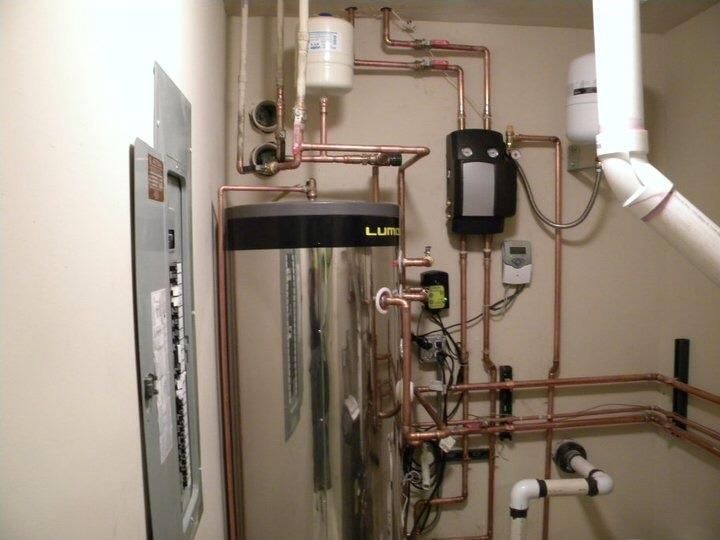 Plumber sets up electric heating boiler at home bathroom.