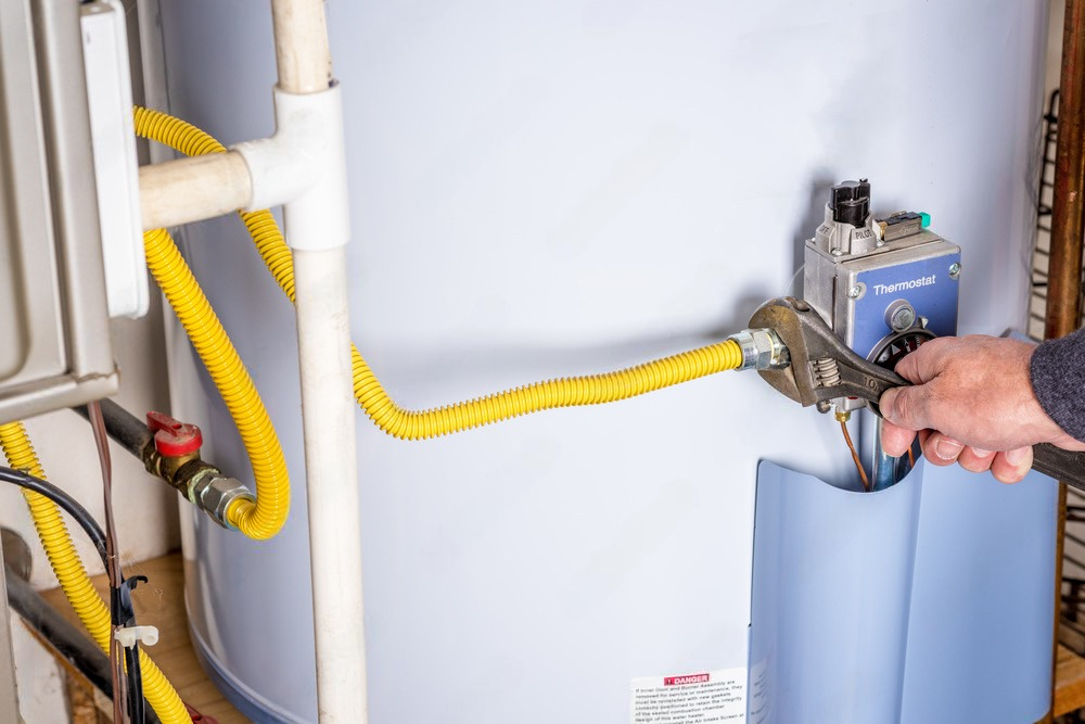 Plumber sets up electric heating boiler at home bathroom.