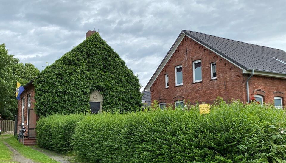 Ein Backsteingebäude mit einem mit Efeu bedeckten Dach.