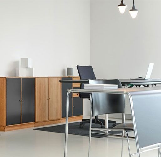 Modern office with wooden cabinets, black chairs, desk, and pendant lights