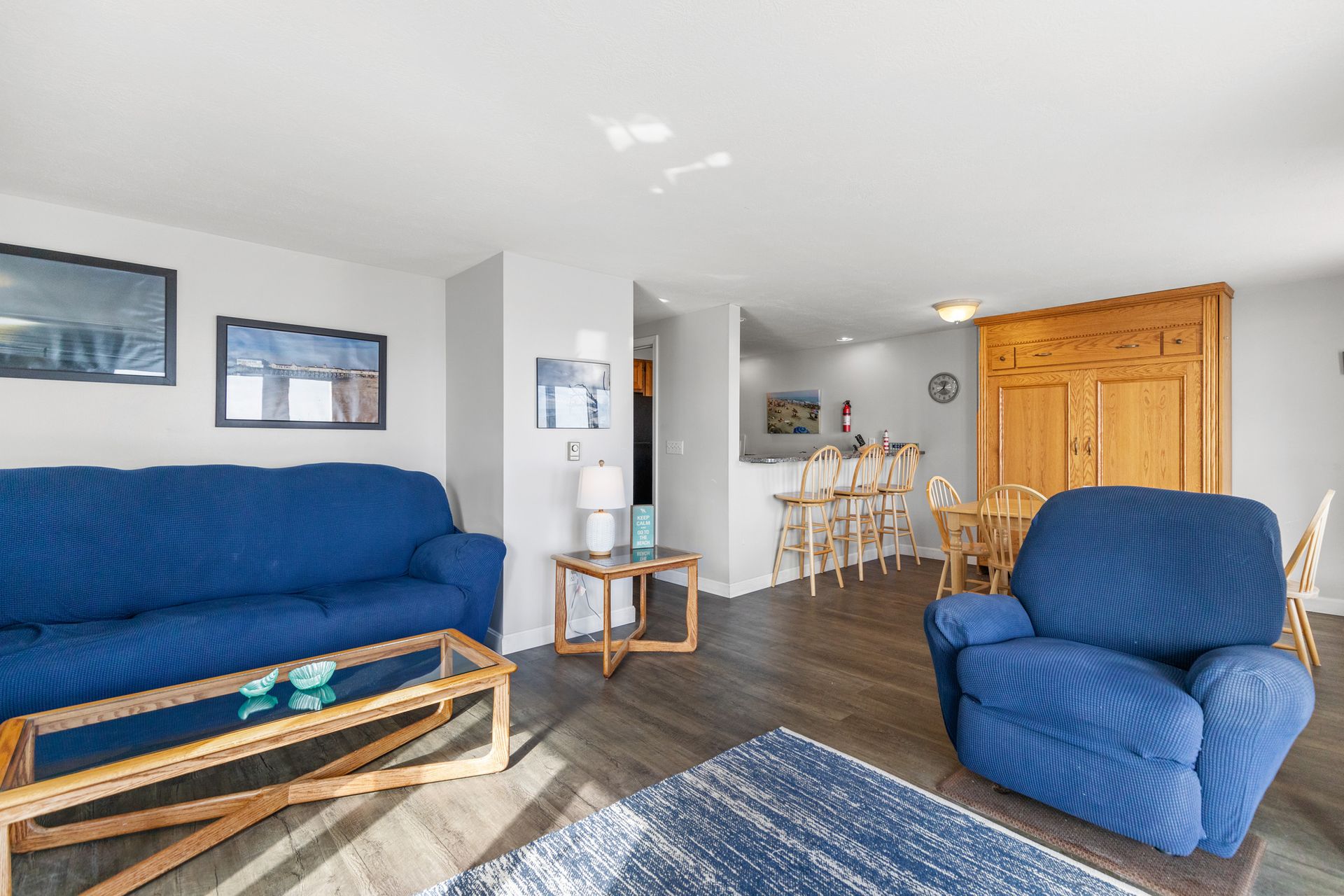A living room with a blue couch and a blue chair.