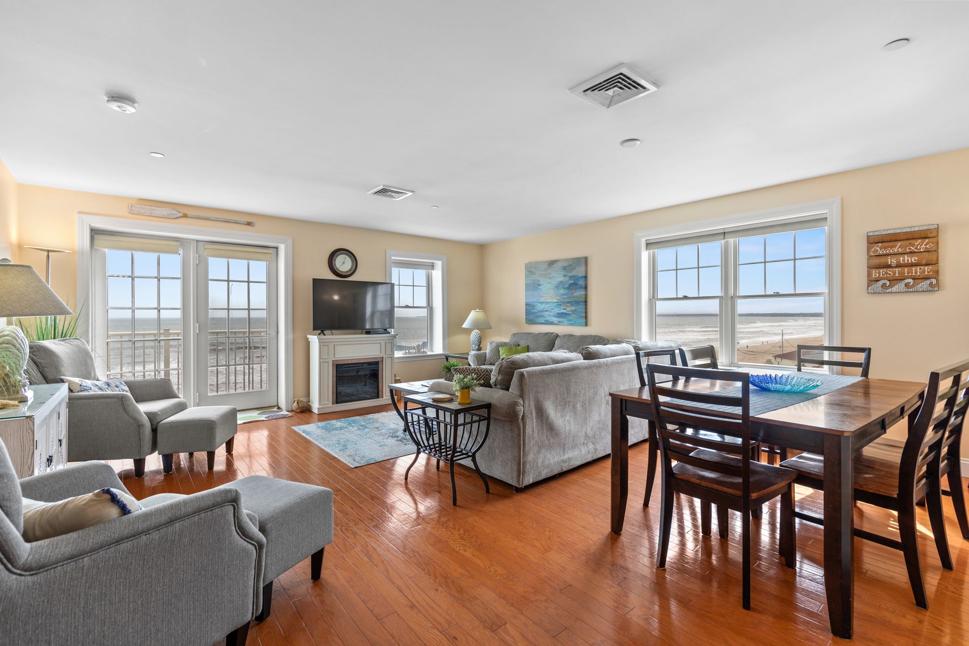 A living room filled with furniture and a sliding glass door leading to the beach.