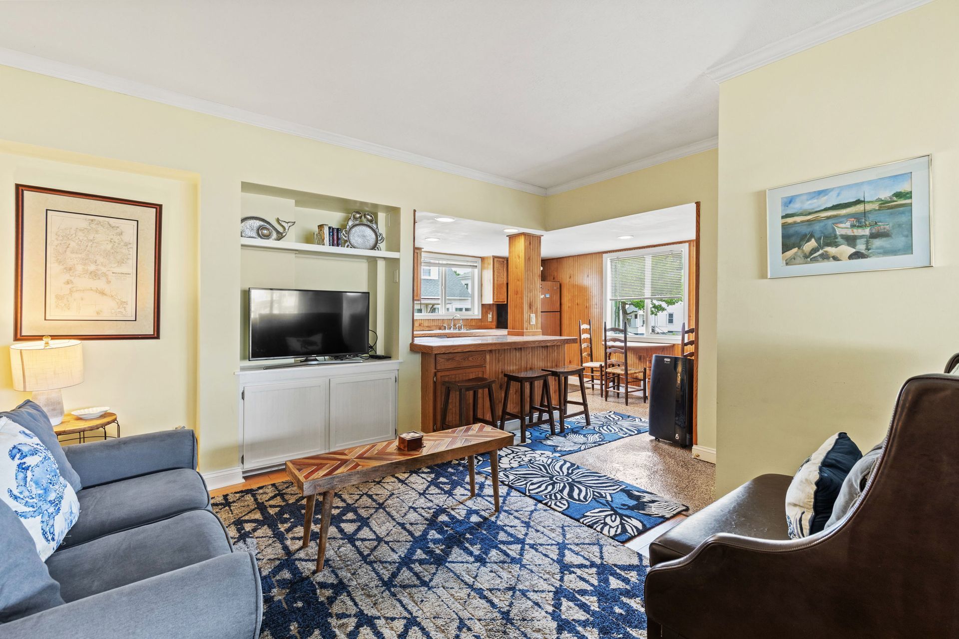 A living room with a couch , chair and television.