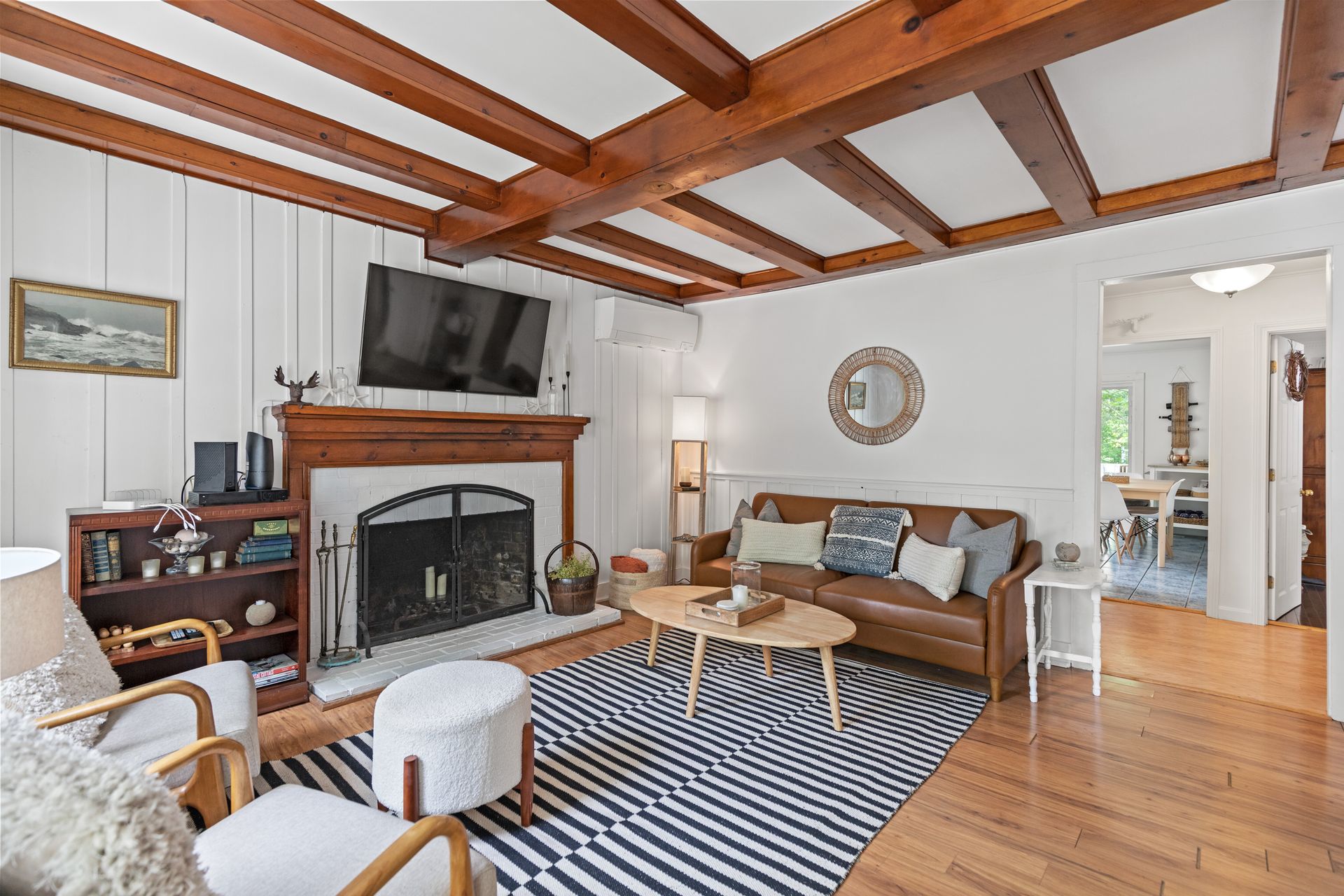 A living room with a fireplace , couch , chairs and a television.
