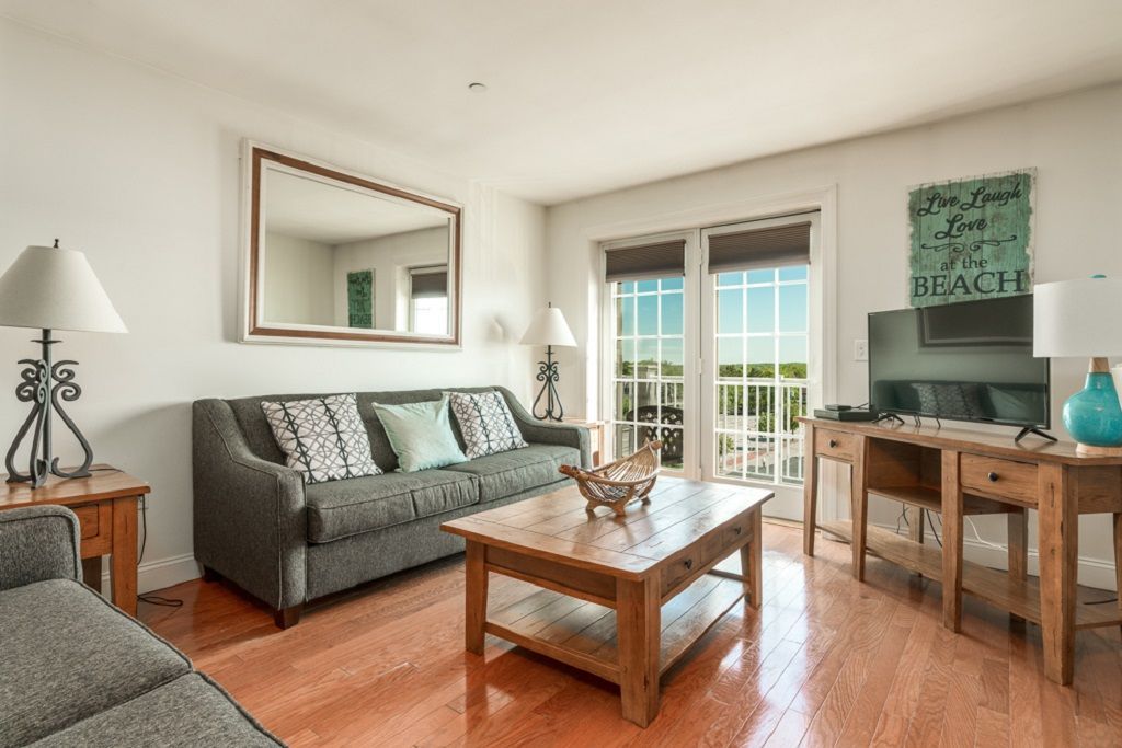A living room with a couch , coffee table , and television.
