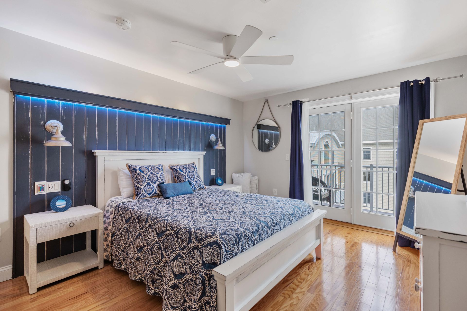 A bedroom with a large bed and a ceiling fan.