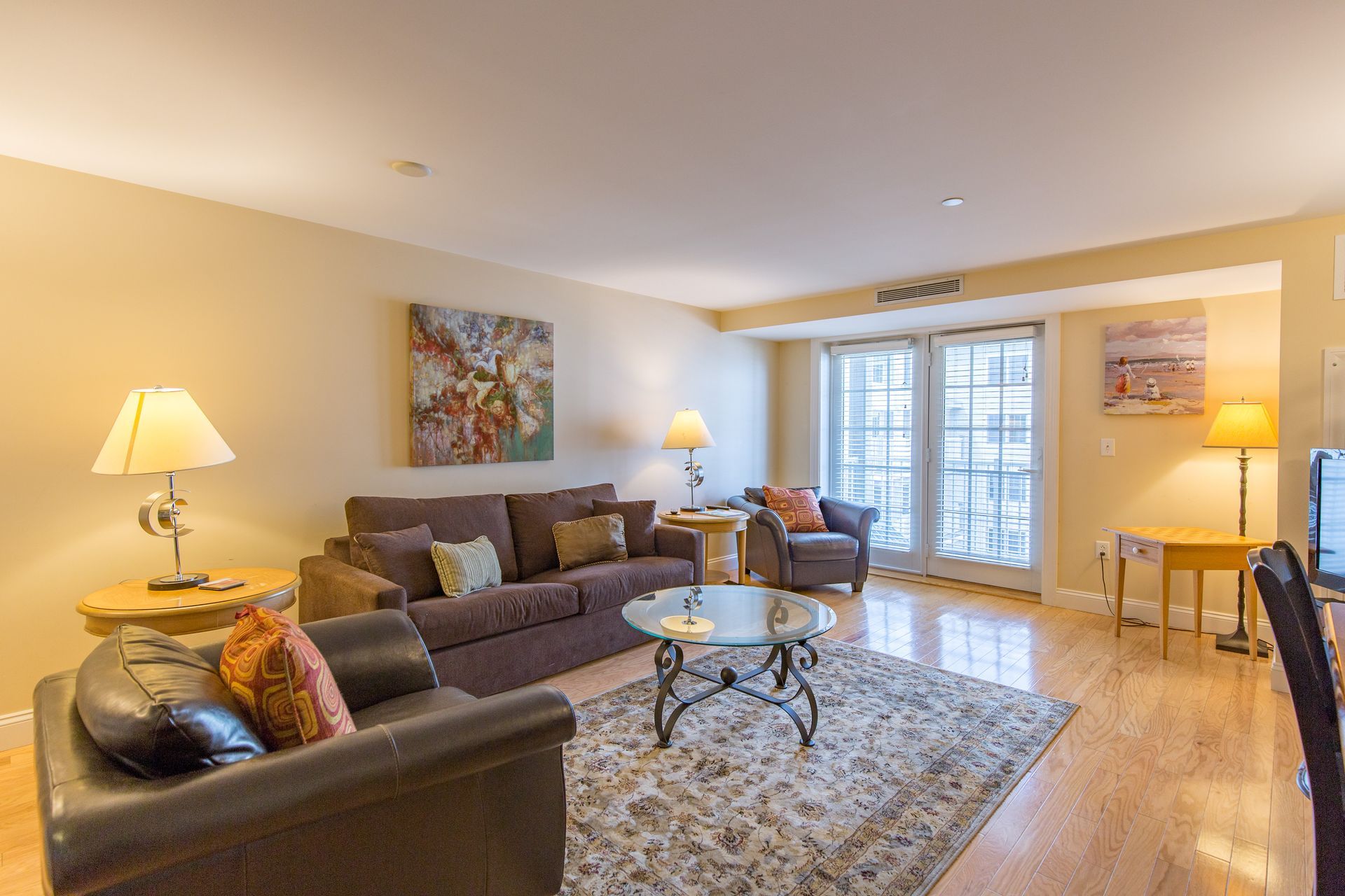 A living room with a couch , chairs , coffee table and television.