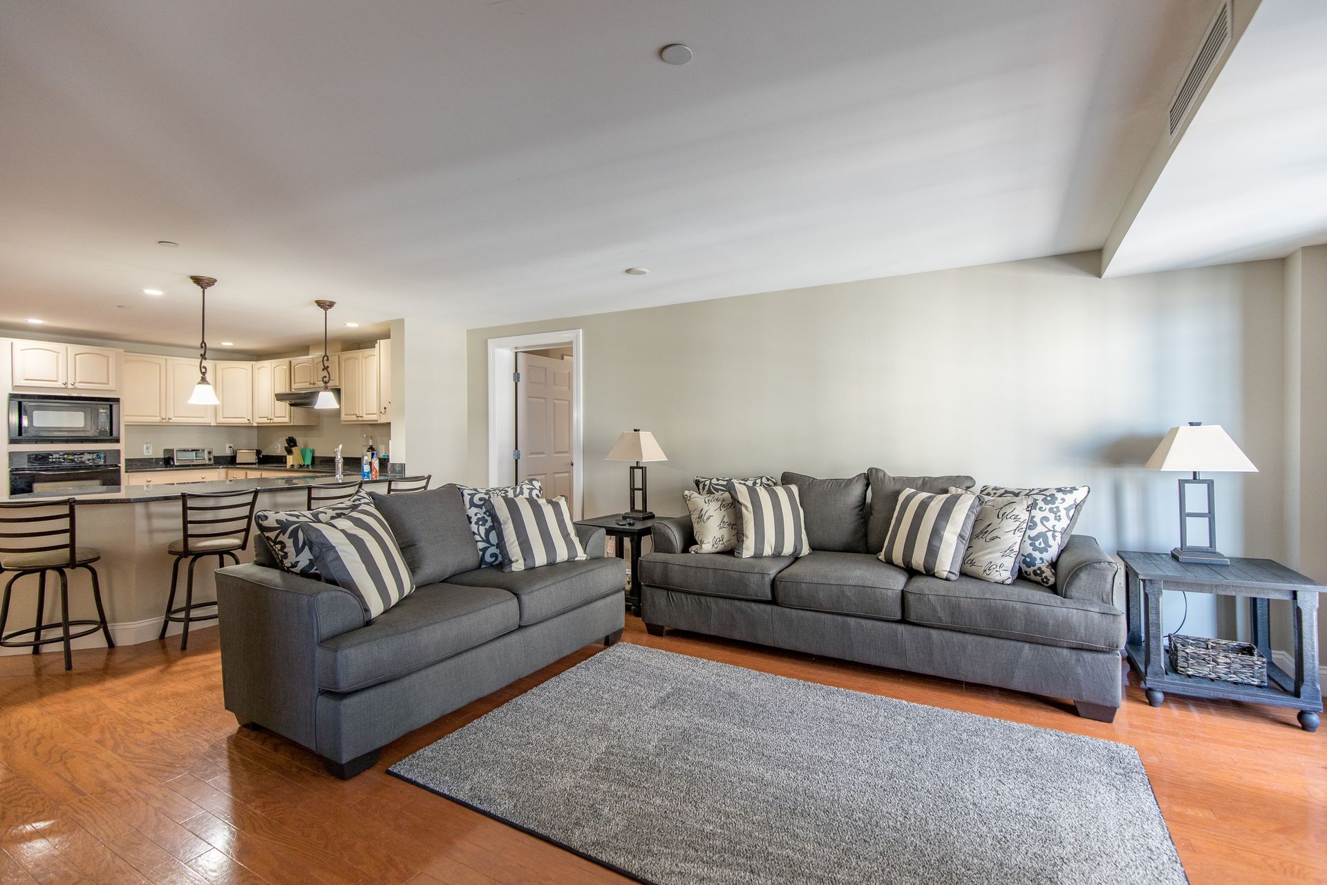 A living room with two couches and a rug.