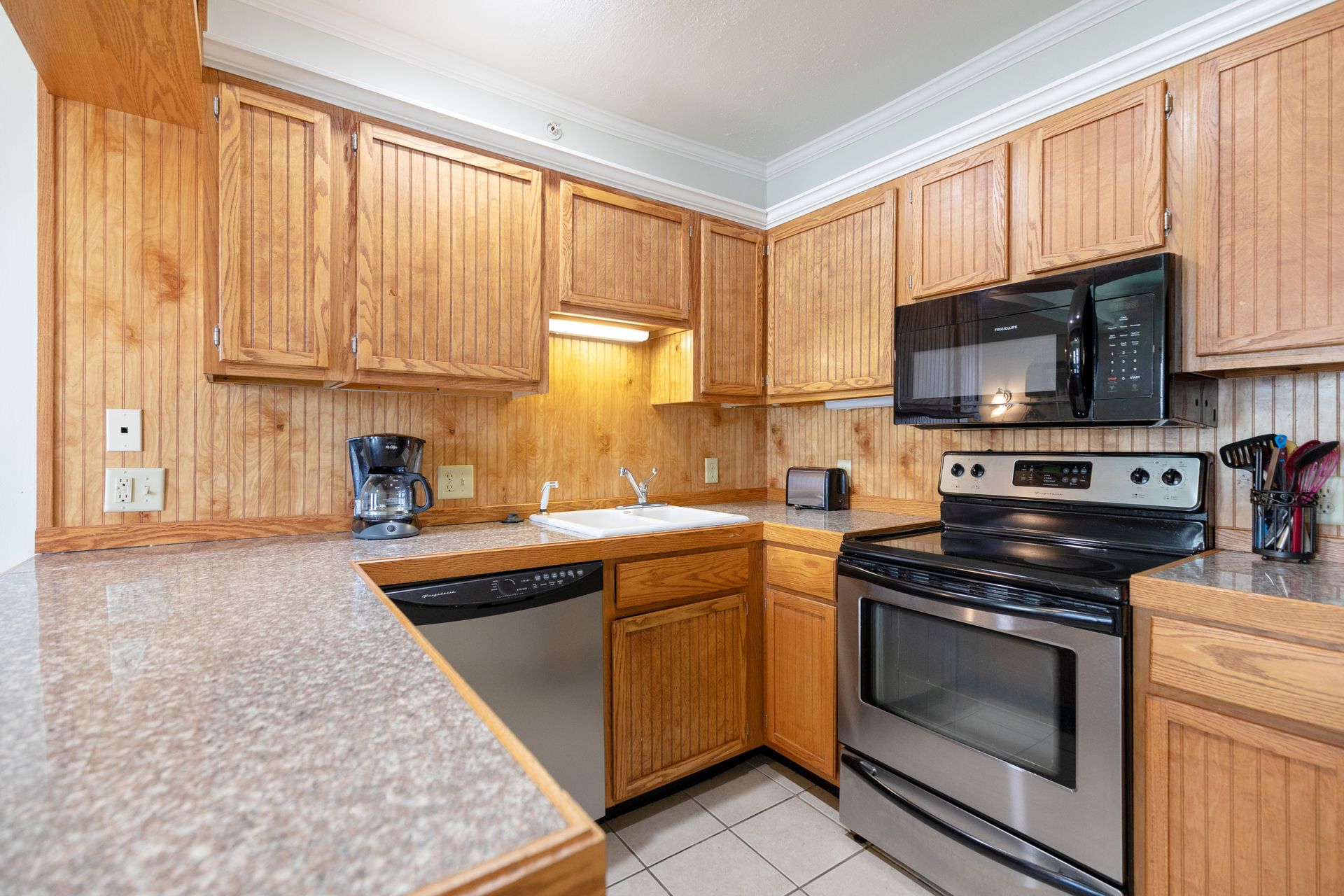A living room with a couch , table , chairs and a kitchen.