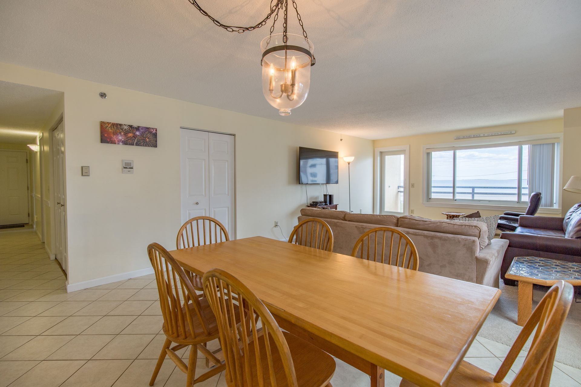 A bedroom with a king size bed , nightstand , lamp and window.