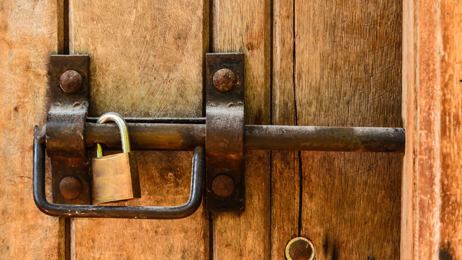 A close up of a wooden door with a metal handle.