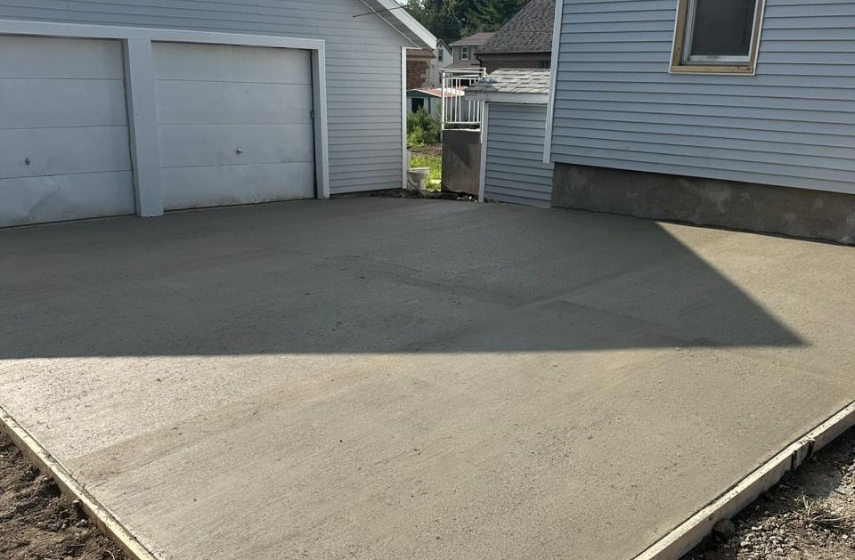 A concrete driveway is being built in front of a house.