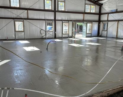 A large room with a concrete floor and a lot of windows.