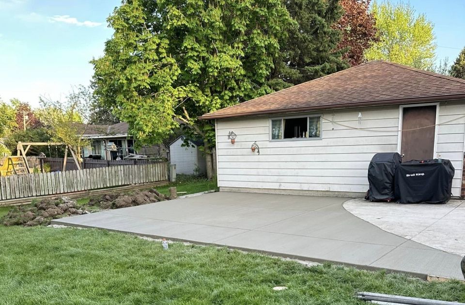 A house with a concrete driveway and a grill in front of it.
