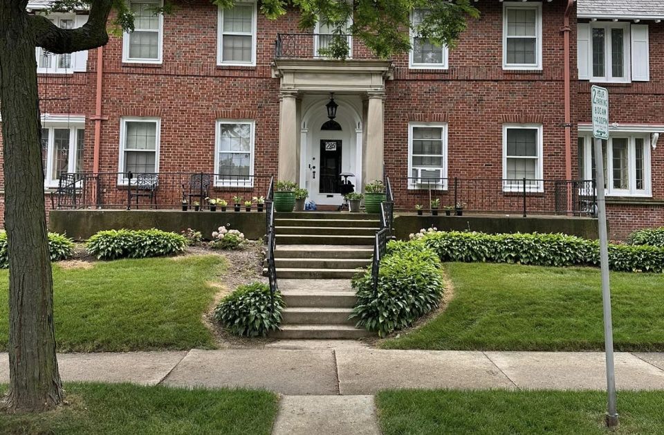 A brick building with stairs leading up to the front door