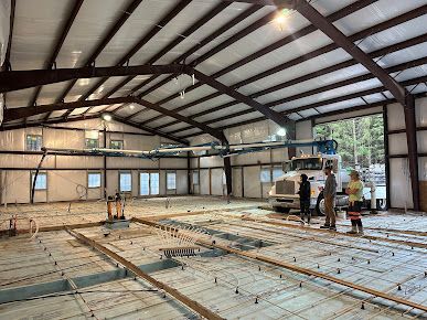 A group of people are standing in a large building under construction.