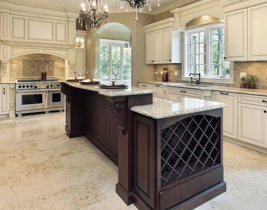 Elegant kitchen with island, white cabinets, stainless steel appliances, and marble floors.