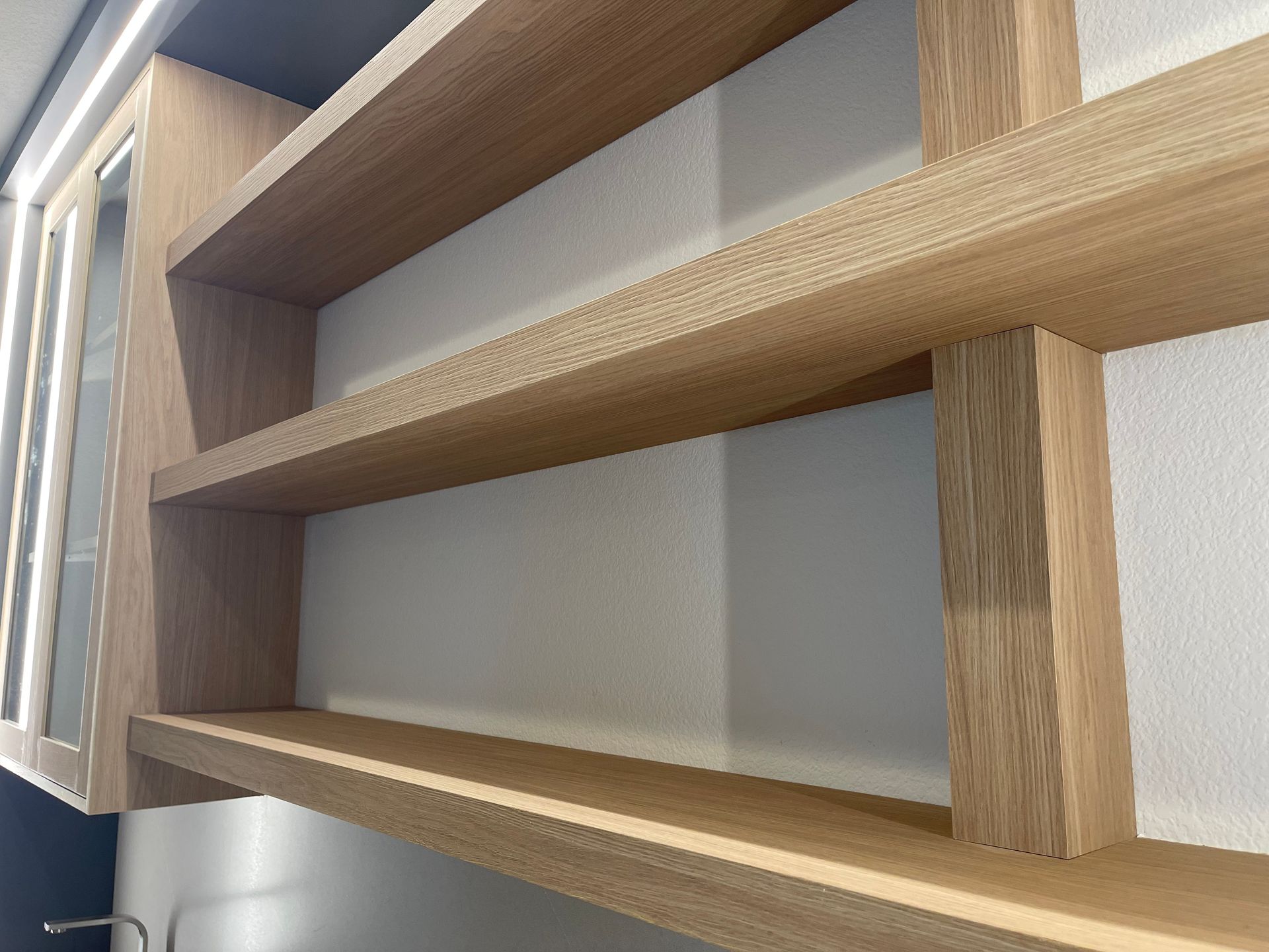 Wooden shelves mounted on a white wall.