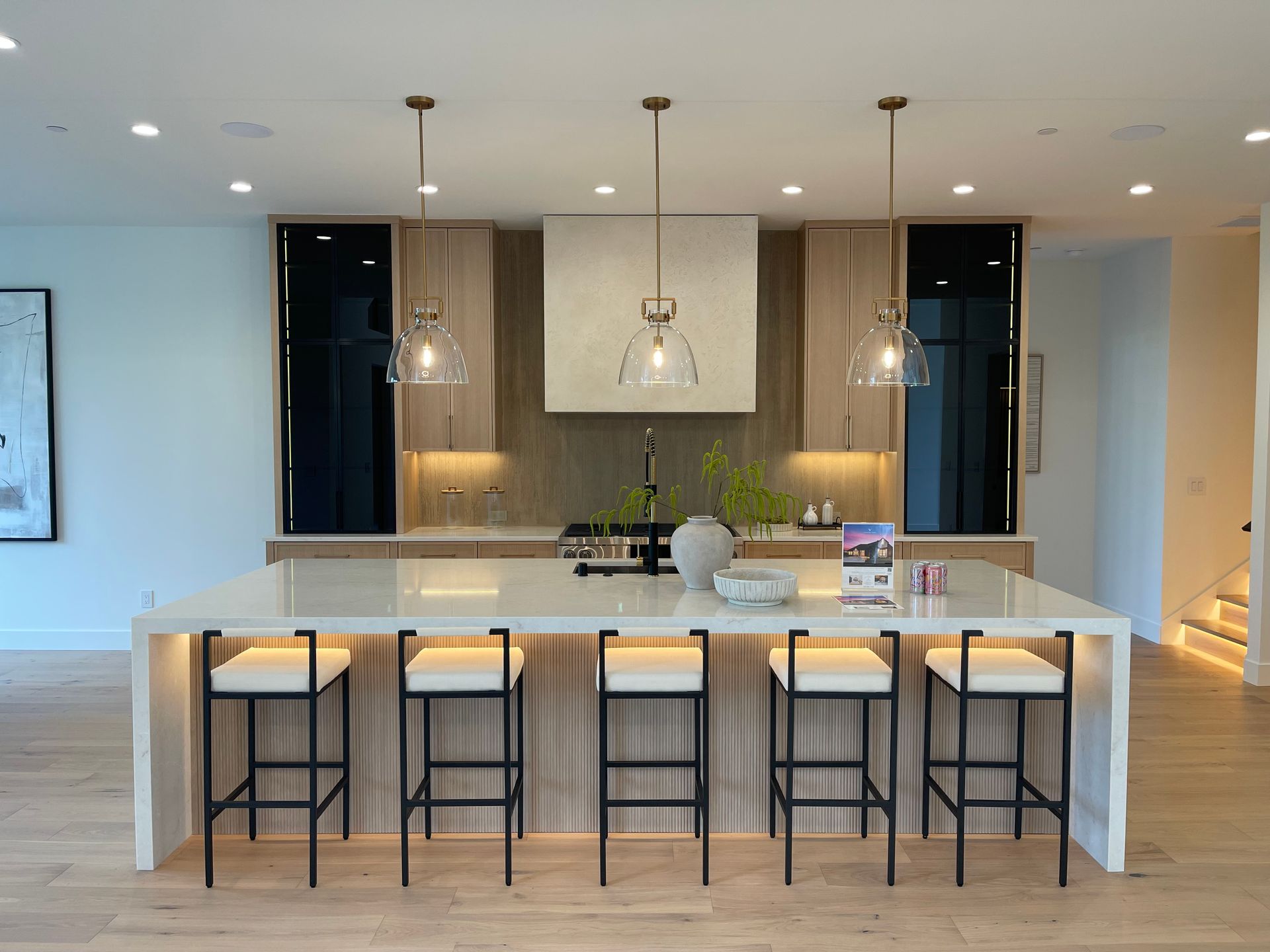 Modern kitchen with large island, five barstools, pendant lights, and open shelving in Portland, Oregon, WA