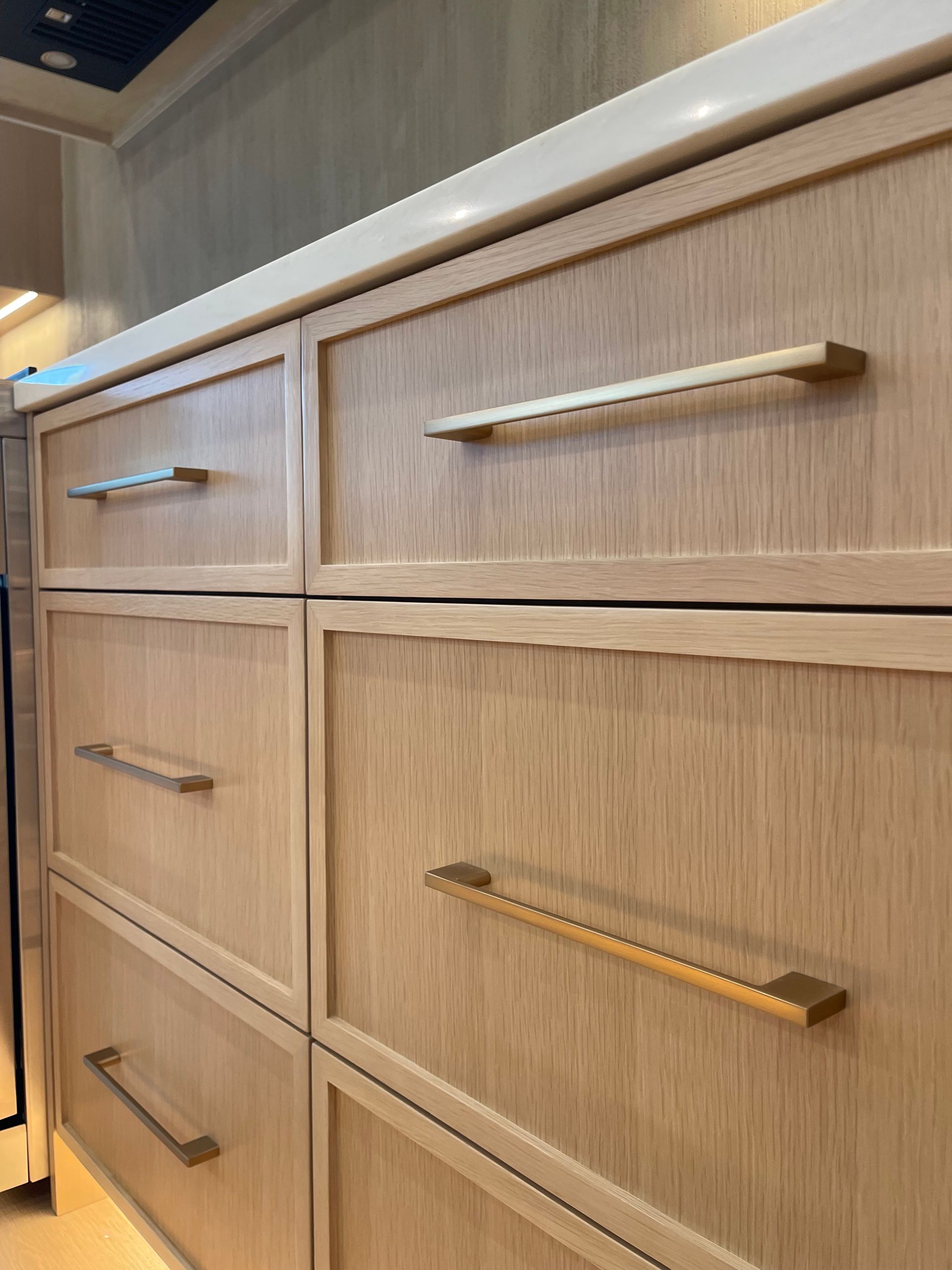 Wooden kitchen drawers and cabinets with brushed metal handles in a modern interior in Portland, Oregon, WA