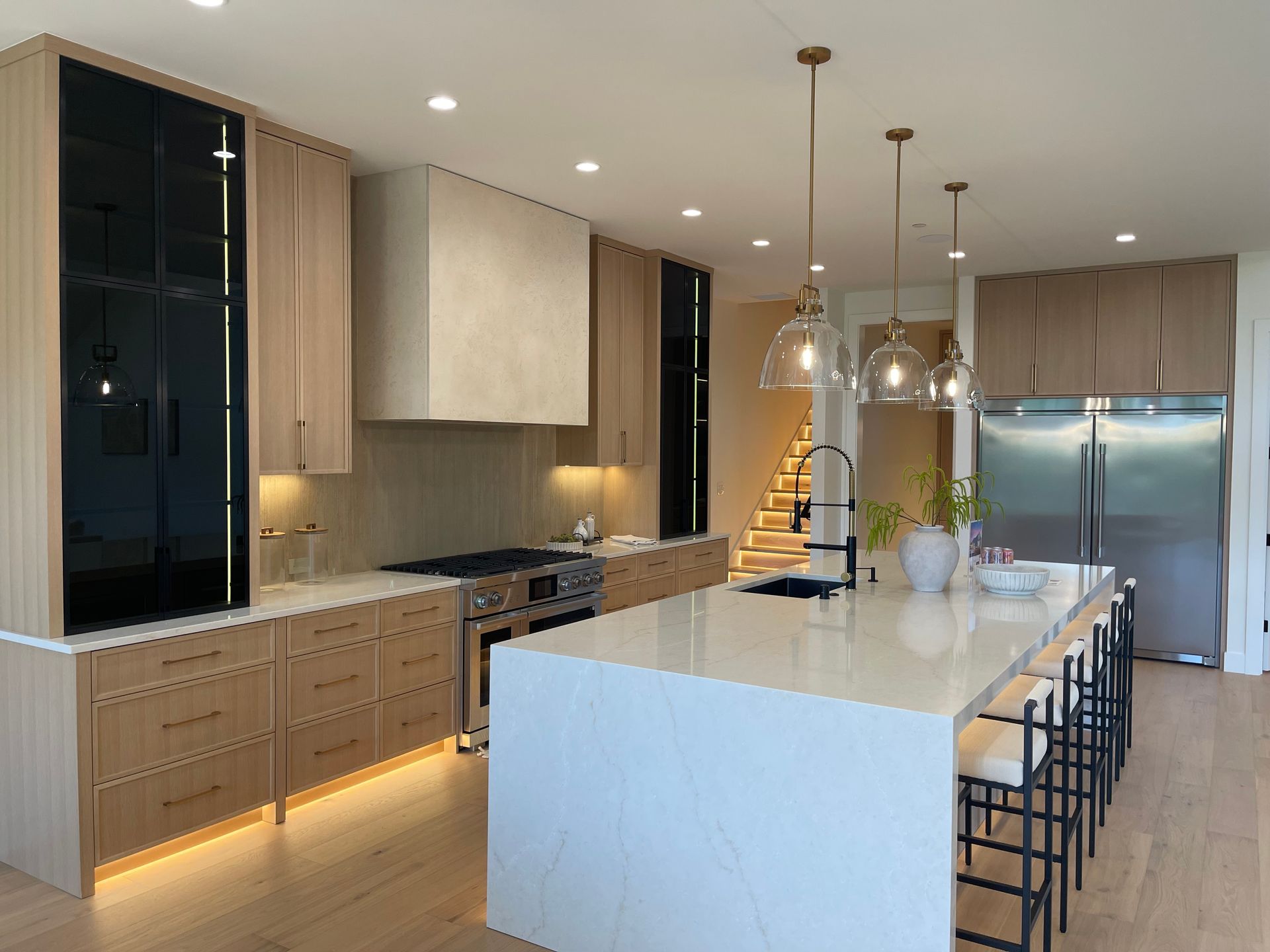 Modern kitchen with large island, wood cabinetry, stainless appliances, and pendant lights in Portland, Oregon, WA