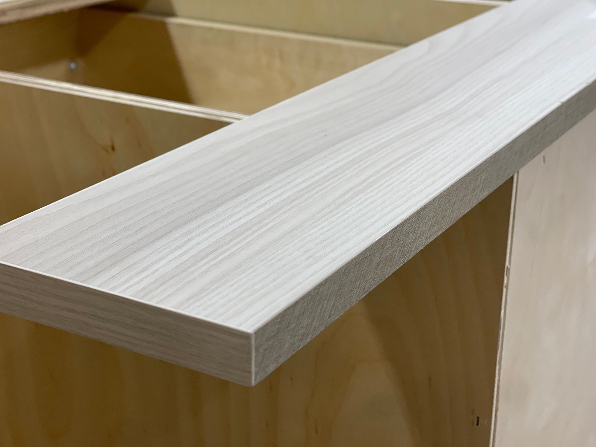 A light wood countertop on top of a cabinet frame, in a workshop.