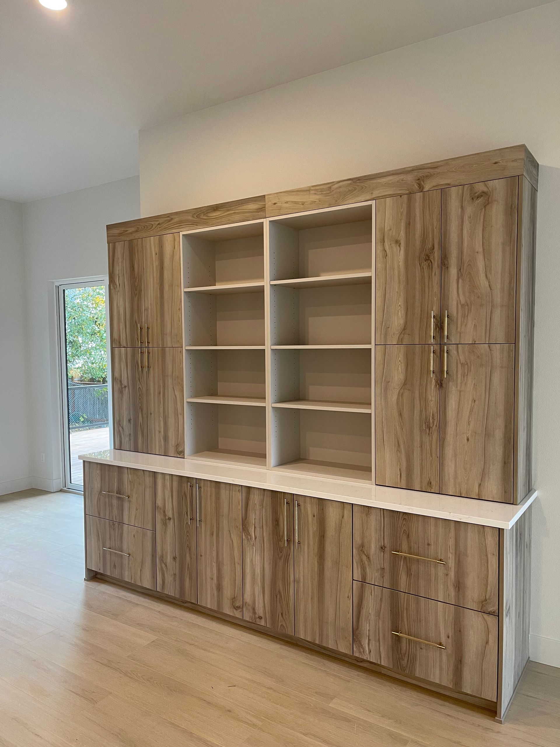 Built-in wooden cabinetry with open shelves and closed storage, on a white countertop. Pro-techwoodworking. Portland.