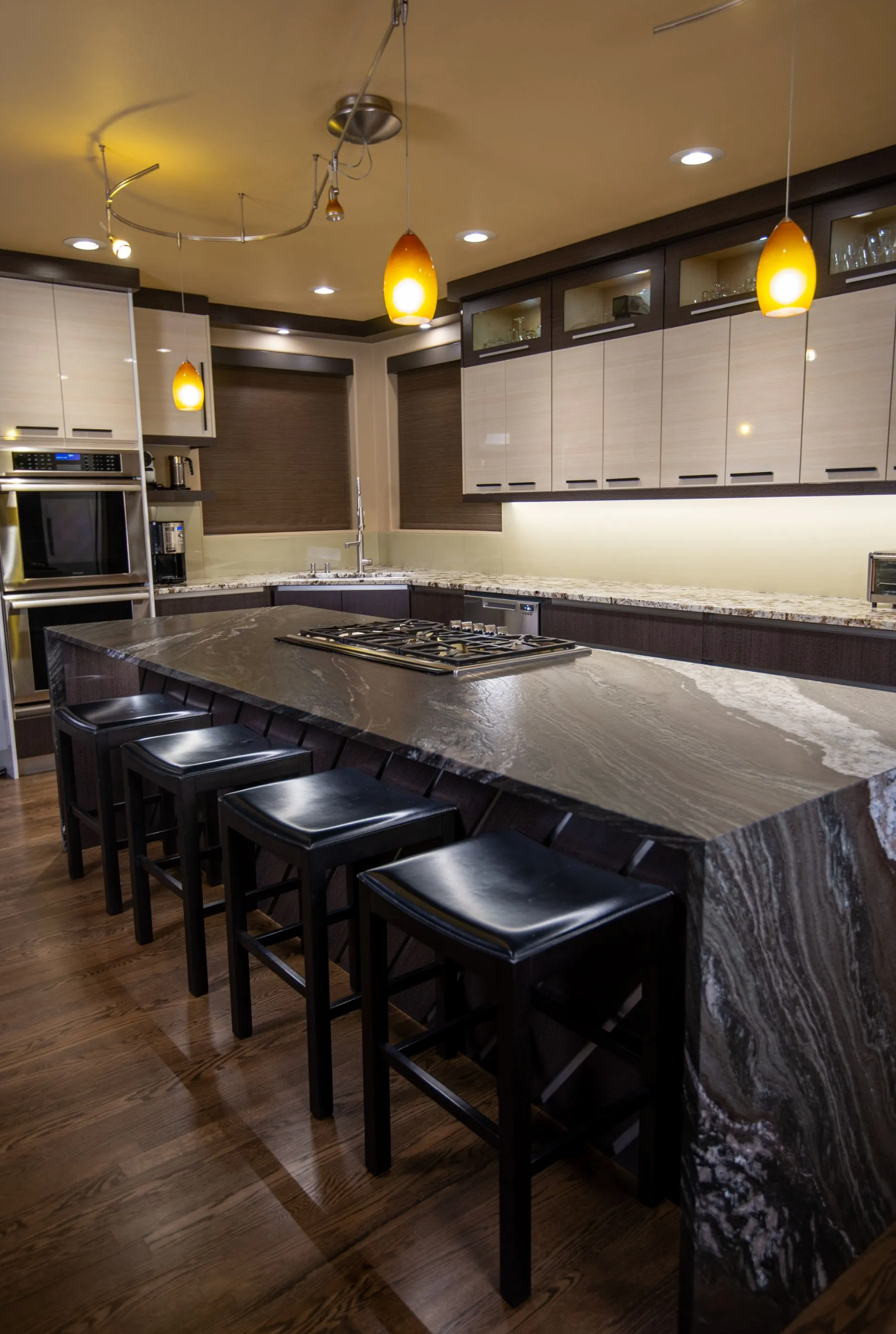 Dark wood kitchen island and white upper cabinets in contemporary layout in Portland