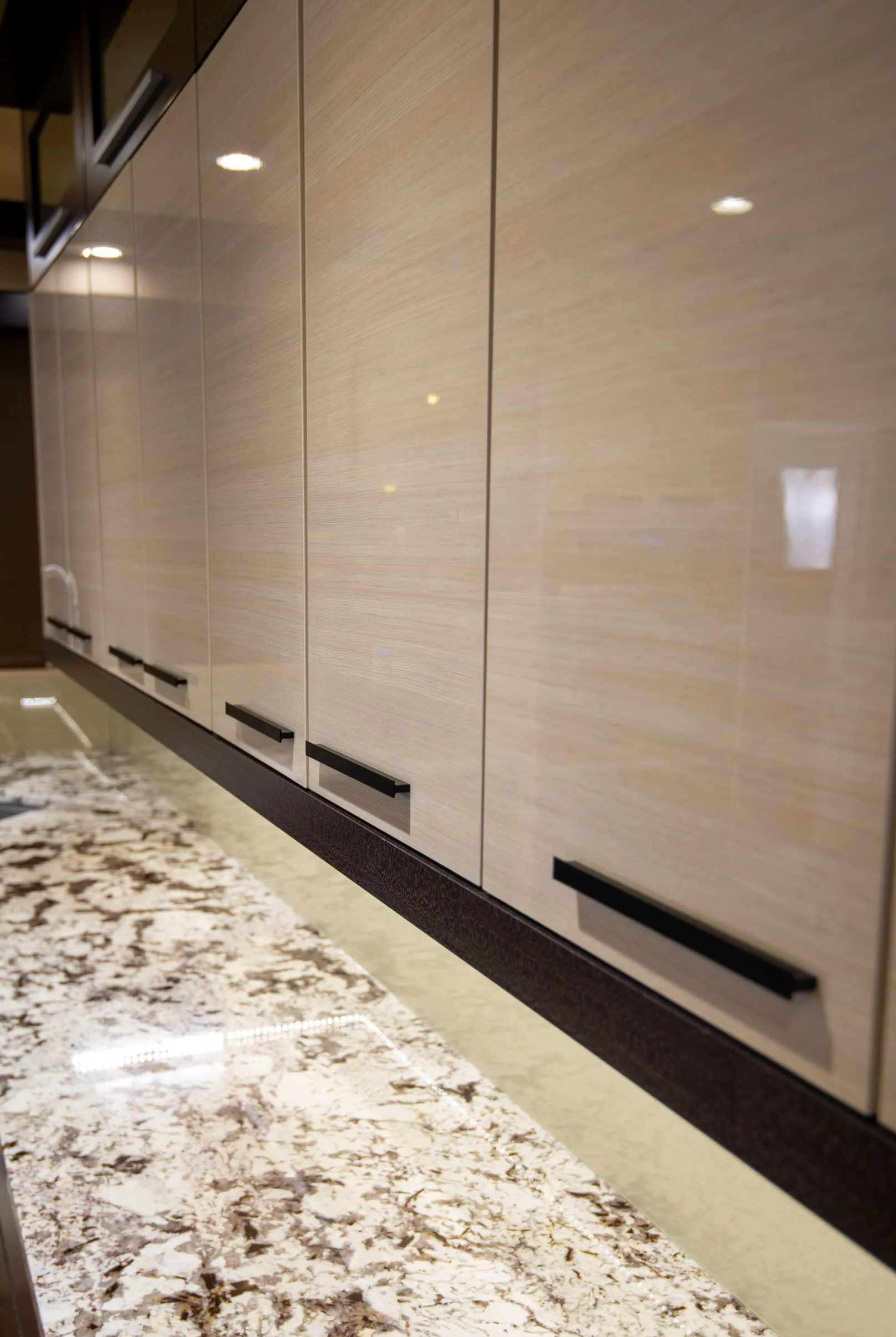 Glossy slab cabinet doors with minimalist hardware in modern kitchen in Portland by Pro-Tech Woodworking