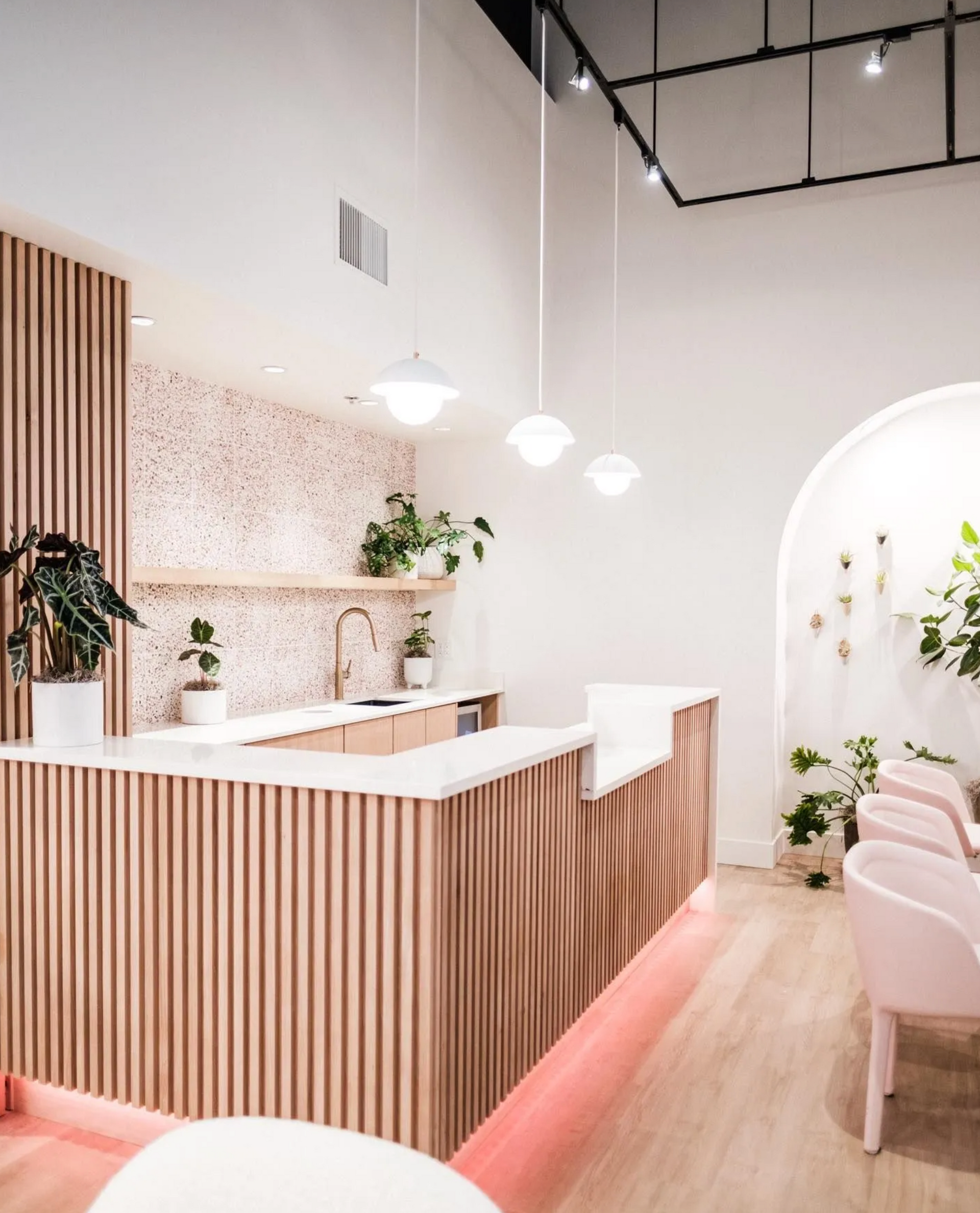 Reception desk with slatted wood front and stone top in modern commercial interior