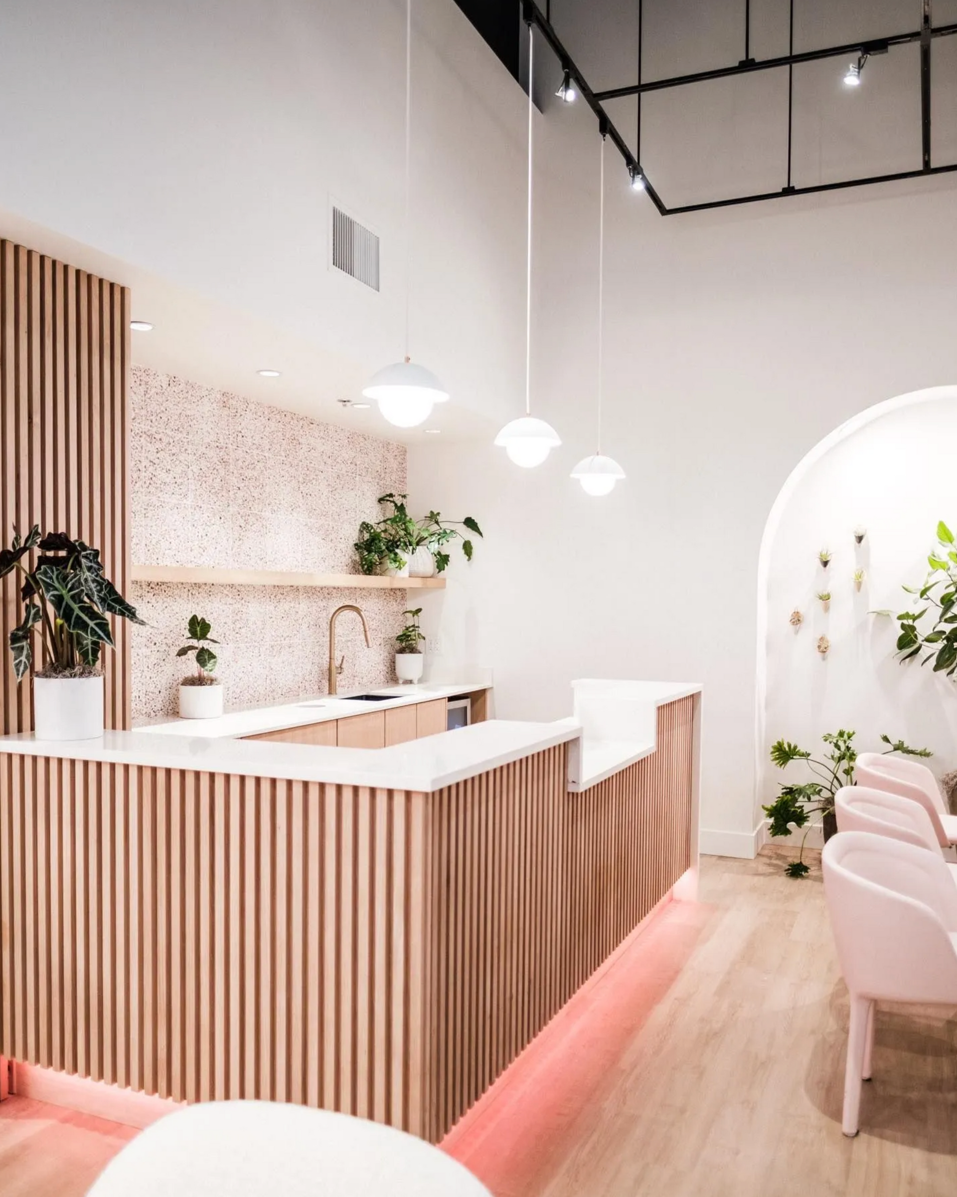 Slatted wood reception desk with rounded edge and wall paneling