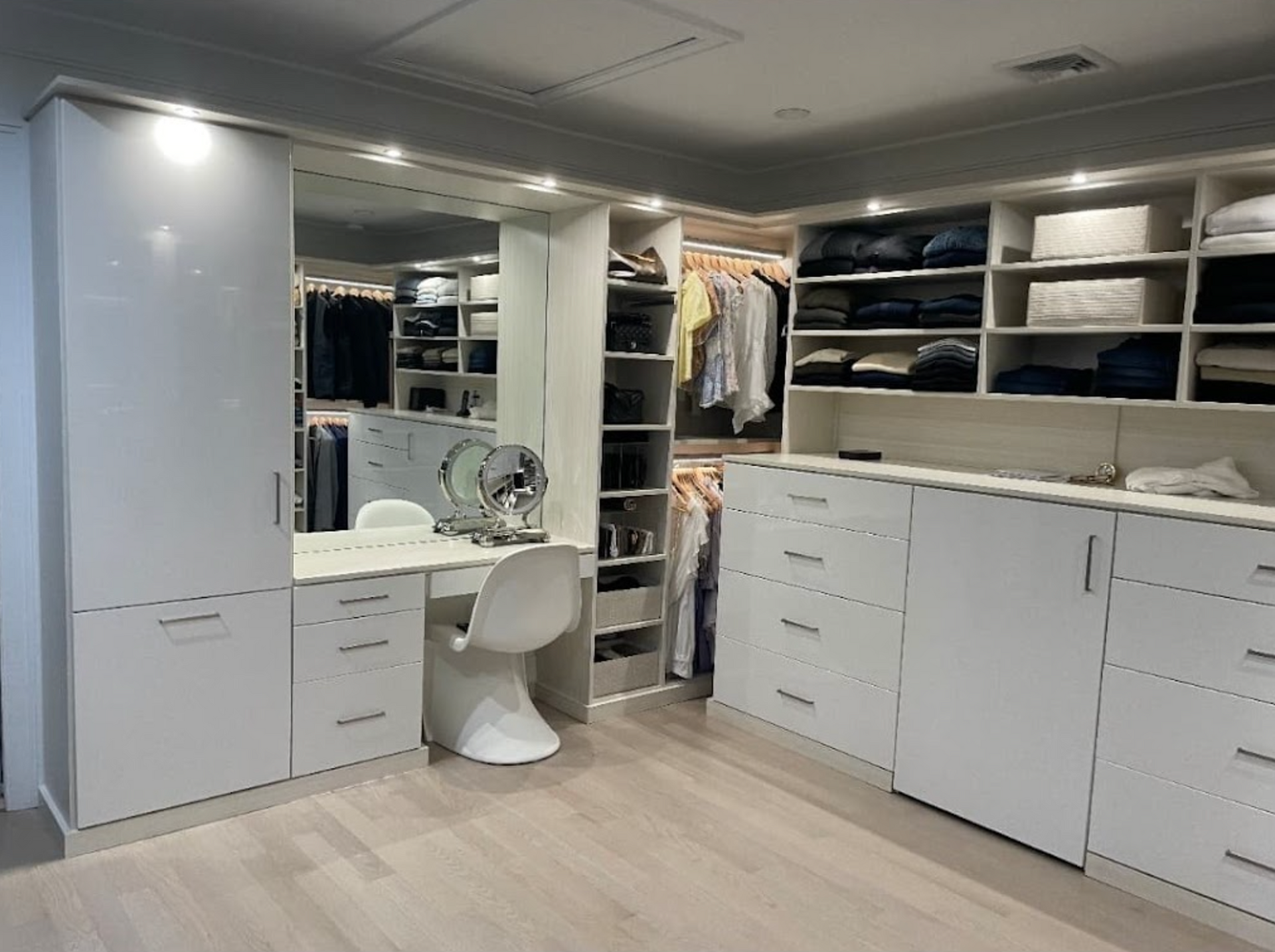 Walk-in closet with white cabinets, drawers, and island — Pro-Tech custom design