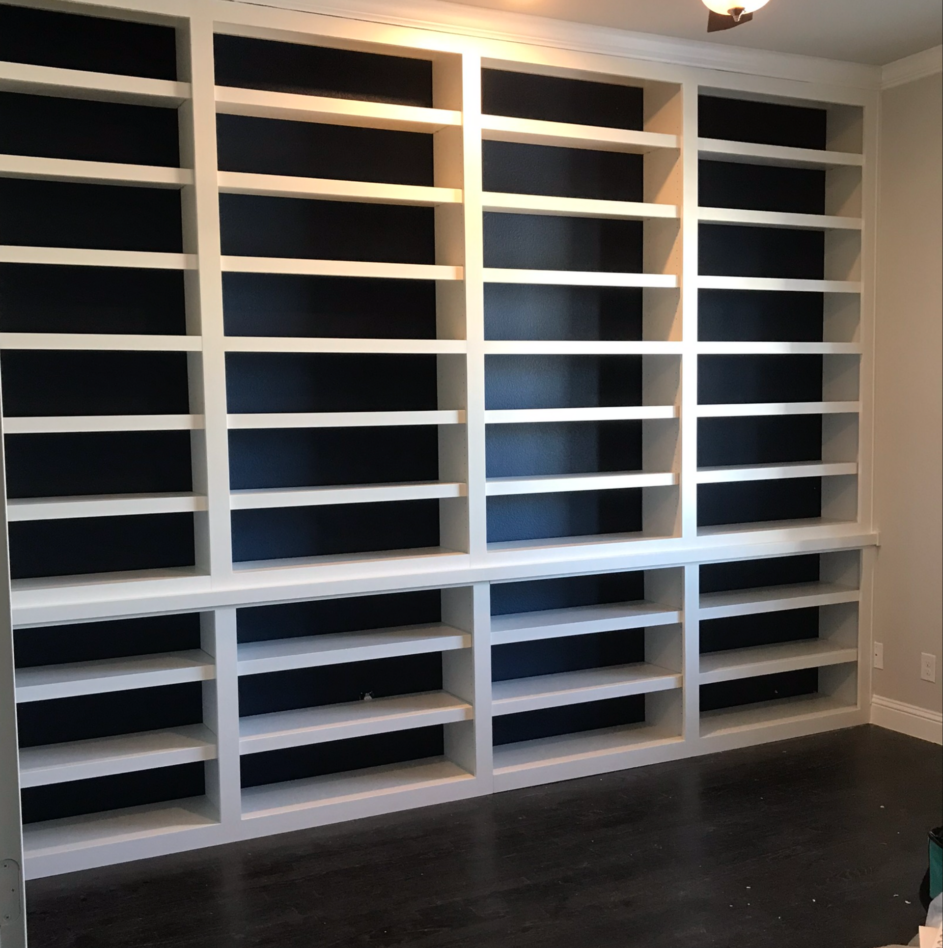 Black and white built-in bookcase with open shelves in progress in Portland