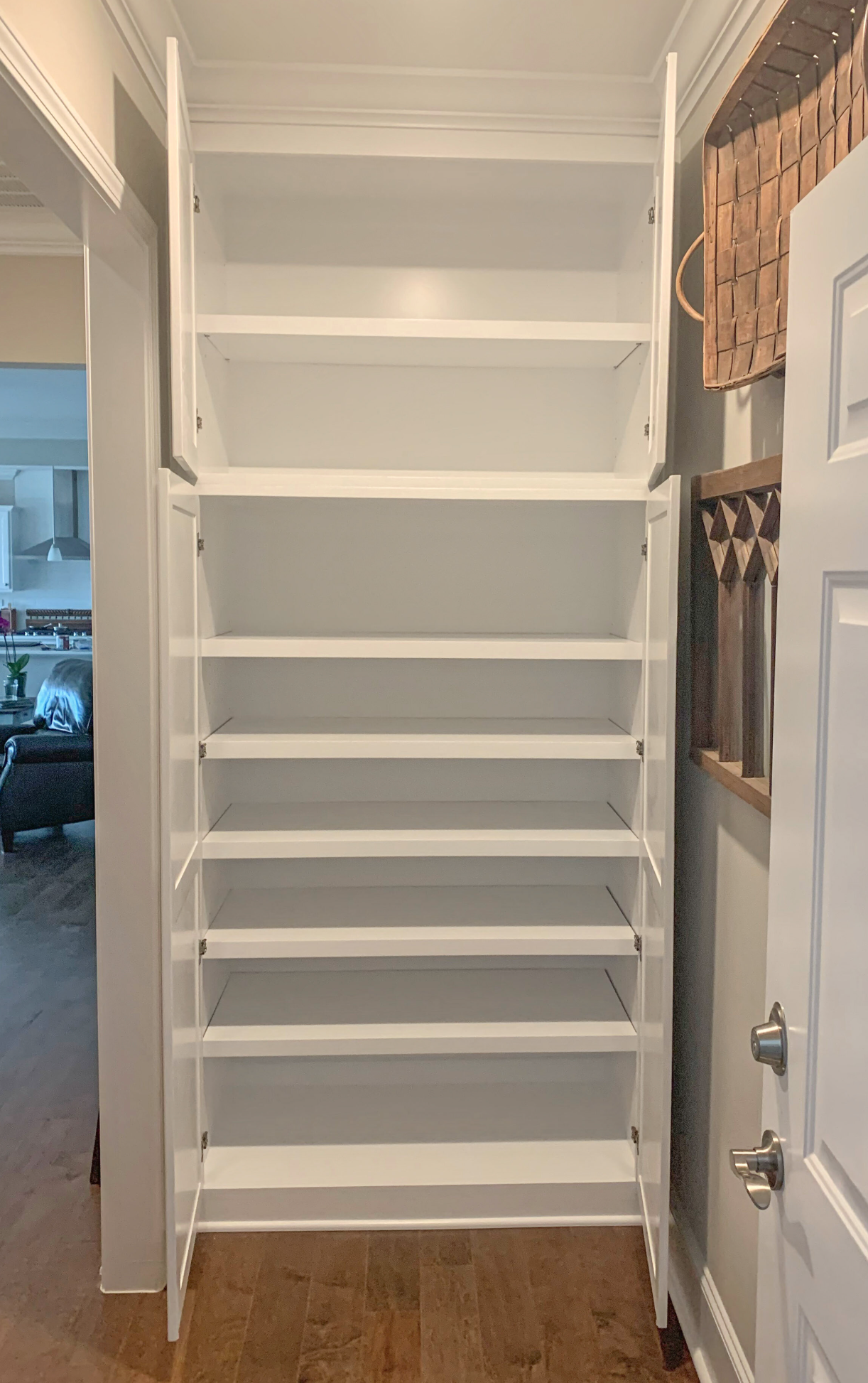 White shelving system with adjustable rails and open shelves for storage