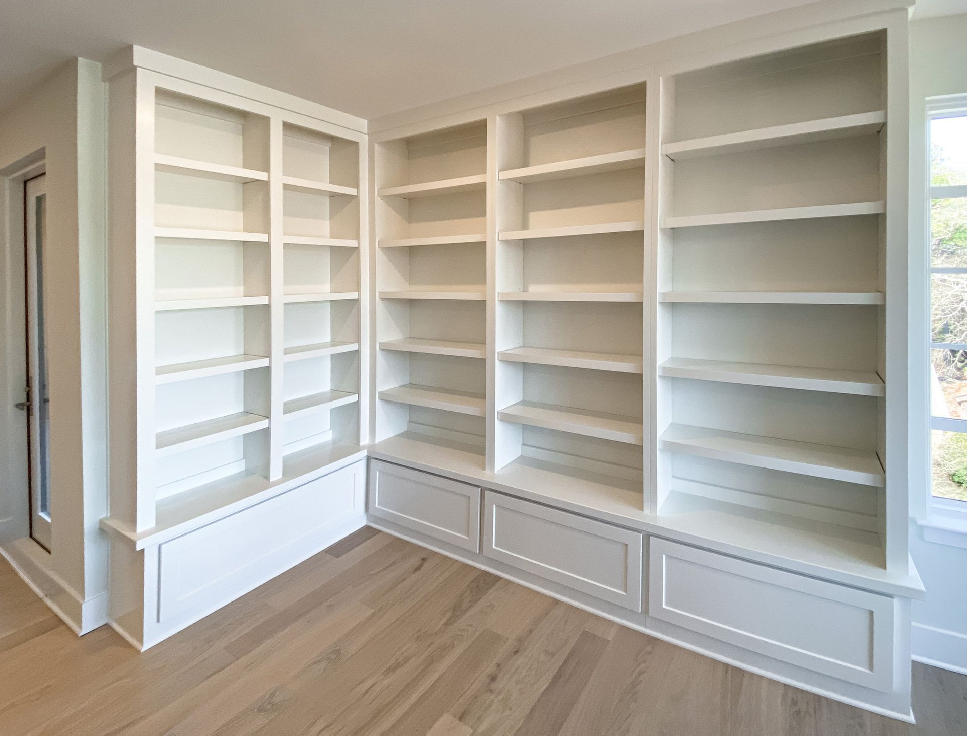 L-shaped built-in white bookcase with lower cabinets — Portland home