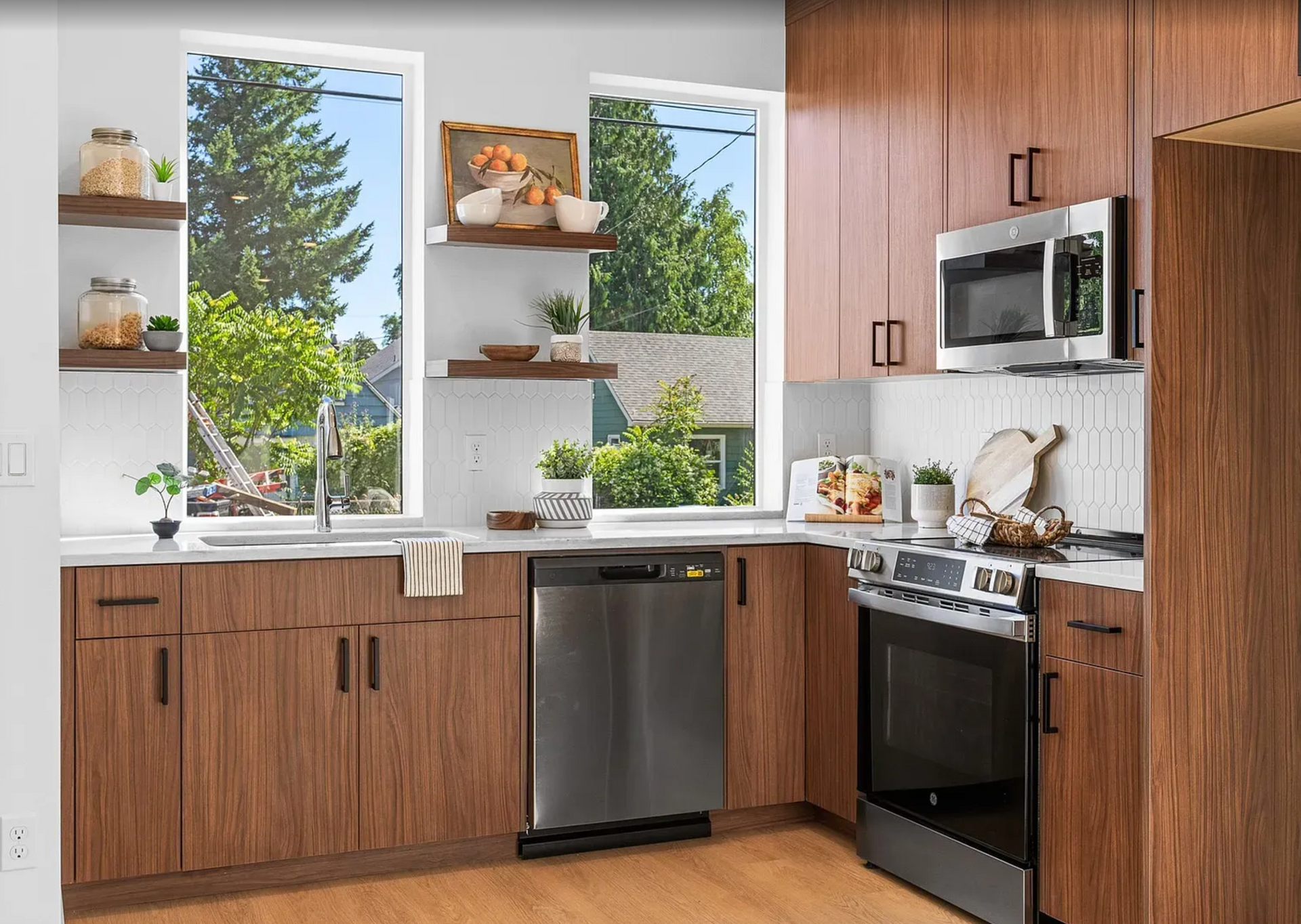 Modern kitchen with wood cabinets, stainless steel appliances, and a view.
